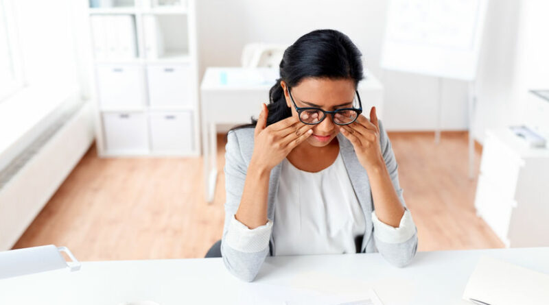 business, overwork, deadline, vision and people concept - tired businesswoman with glasses working at office and rubbing eyes